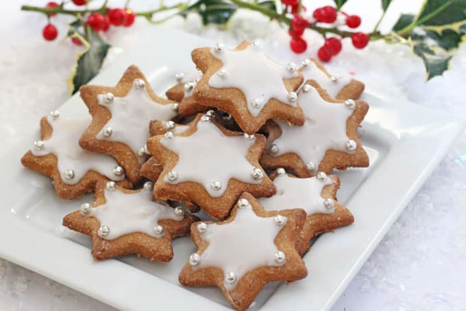 A healthier version of these delicious Christmas Gingerbread Star Cookies made with wholemeal spelt flour, coconut sugar and maple syrup, served on a square,white plate all ready to eat. 