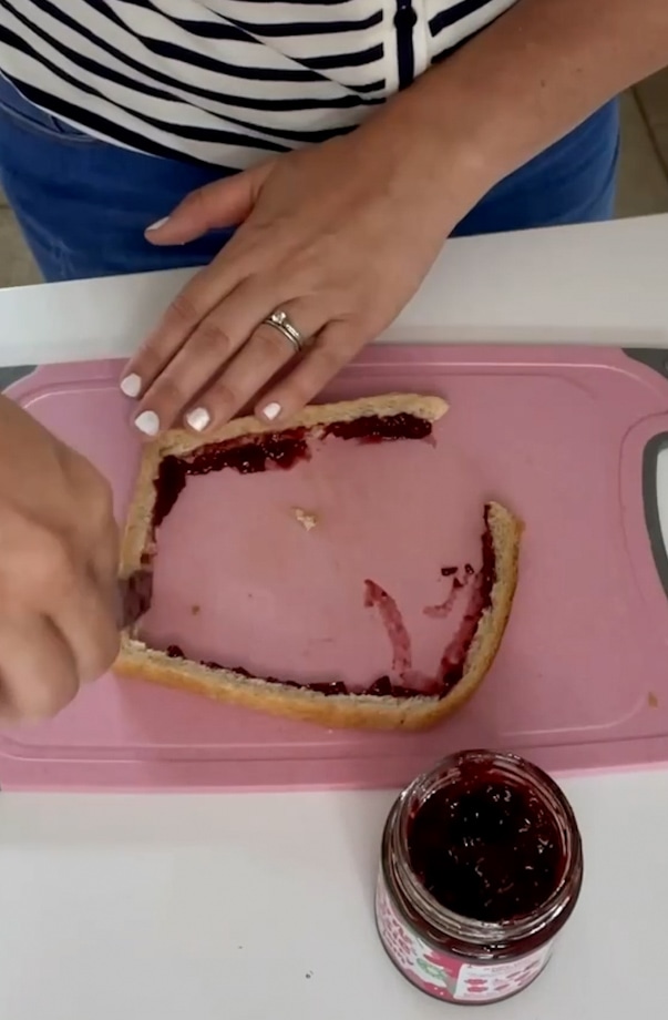 Jam being spread around the crust.
