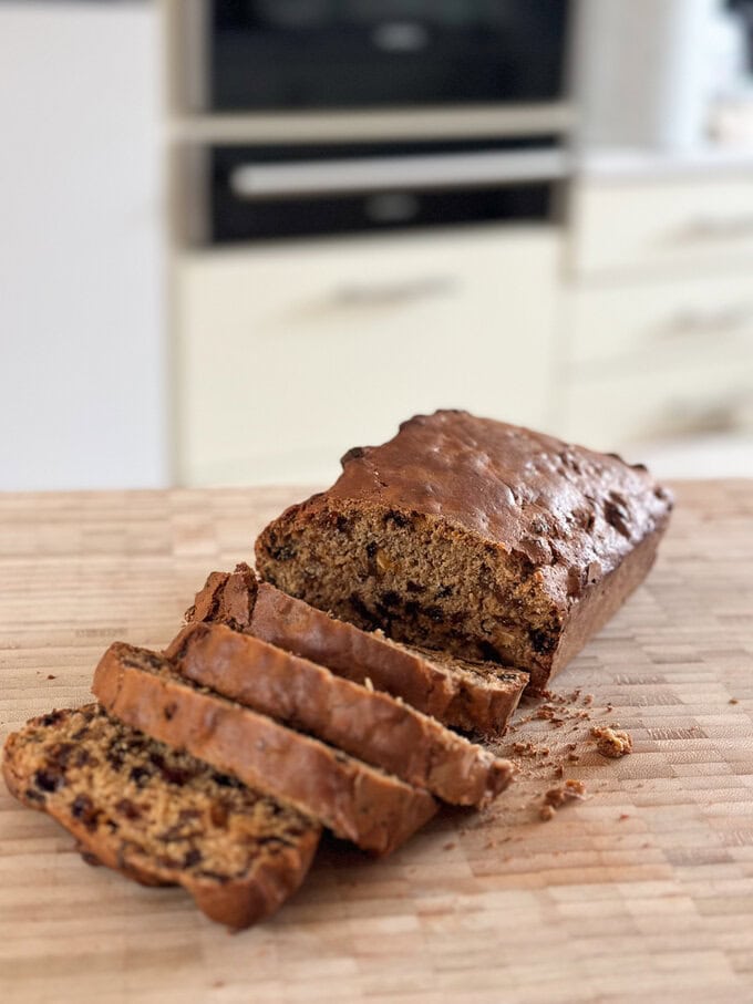 Sliced Irish Barmbrack displayed on  a wooden  chopping board.
