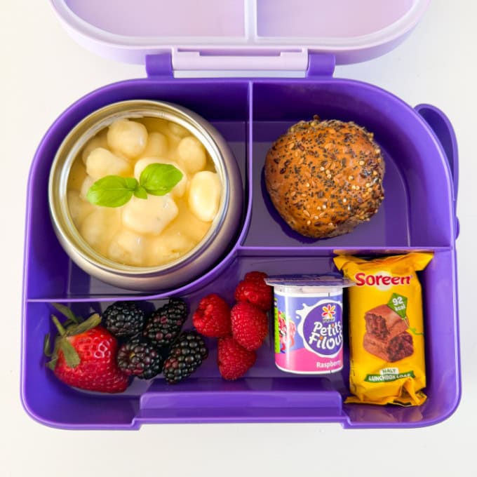 Gnocchi Mac & Cheese served in a bright purple hot & cold lunch box. with fresh berries and a seeded roll.
