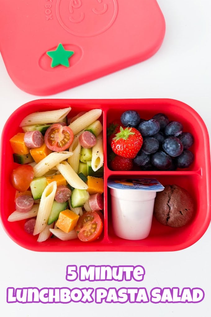 5 Minute Lunchbox Pasta Salad served in a bright red lunch box with fresh berries, yogurt and a sweet treat.